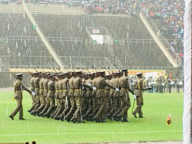 Raining as people march in the stadium