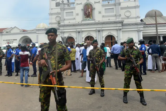 Sri Lankan security personnel keep watch outside a church