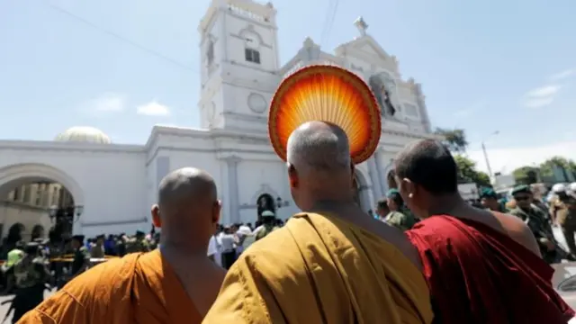 Buddhist monks stand in front of St Anthony's,