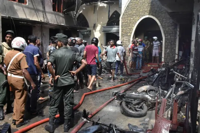 Locals and police gather at the Secon church Batticalova central road in Colombo, Sri Lanka, 21 April 2019.