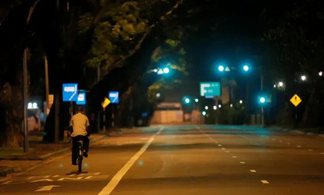 man rides bike after curfew in Colombo