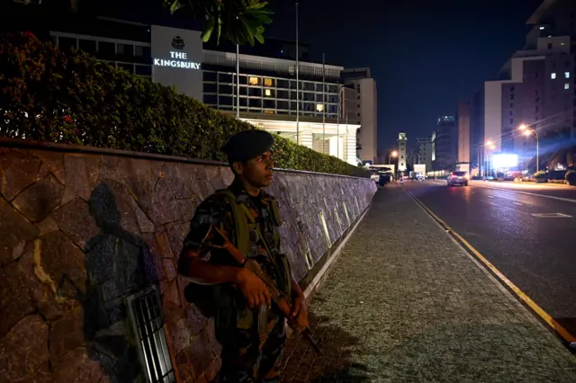 A Sri Lankan soldier stands guard along a street