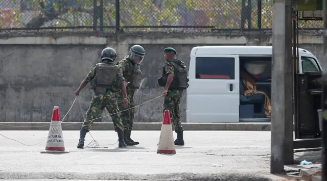 Special Task Force Bomb Squad officers prepare to defuse a suspected van before it exploded near a church that was attacked yesterday in Colombo