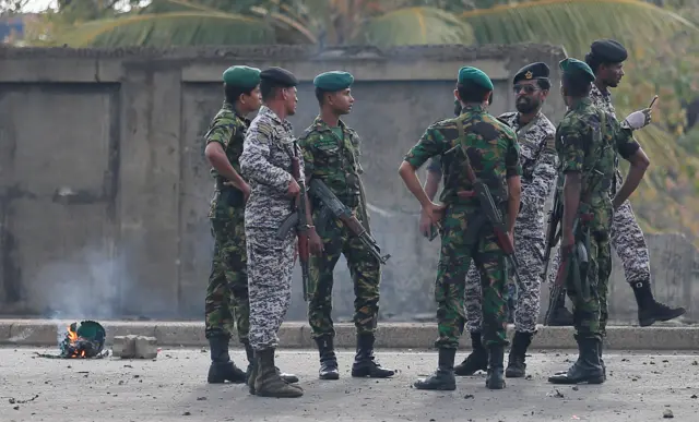 Special Task Force Bomb Squad officers inspect the site of an exploded van near a church that was attacked yesterday in Colombo