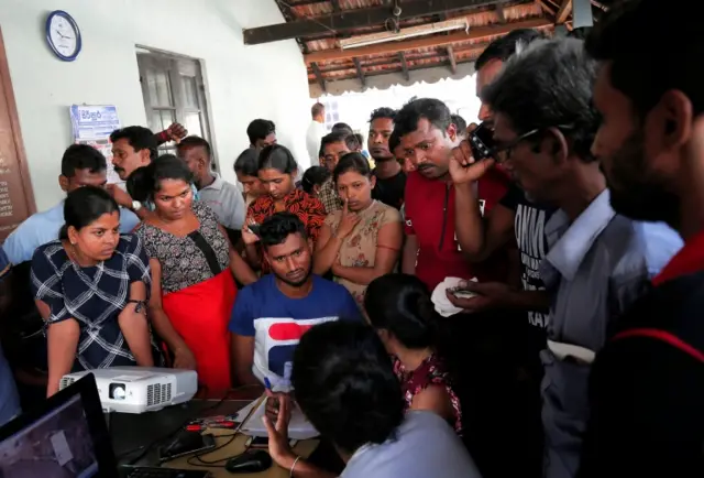 Relatives look at images of victims in Colombo