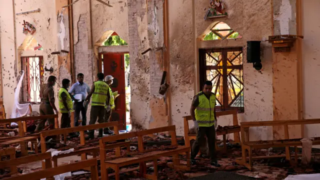 Police officers work at the scene at St. Sebastian Catholic Church