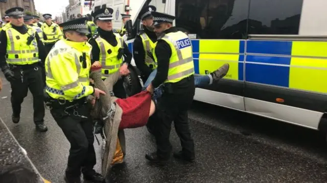 A protester is carried away by police