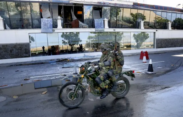 Security officials drive past the Kingsbury, Colombo