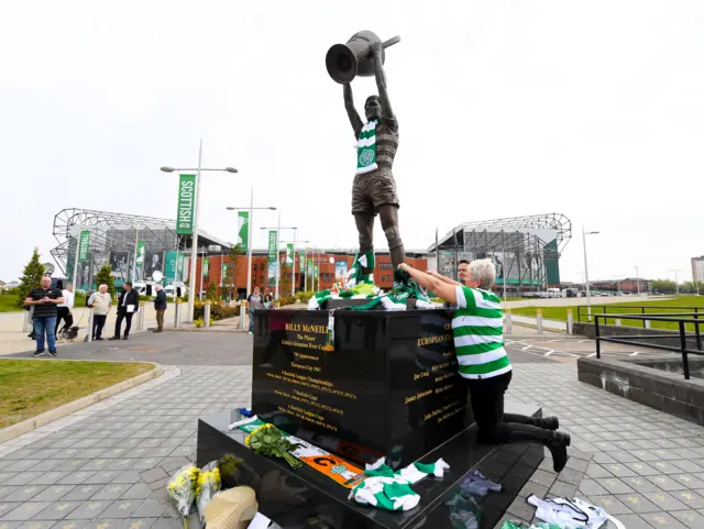 Fans lay flowers, scarfs and jerseys at the Billy McNeill statue