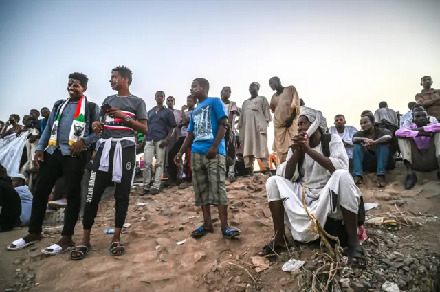 Sudanese protesters sit during a protest outside the army headquarters in the capital Khartoum on April 22, 2019