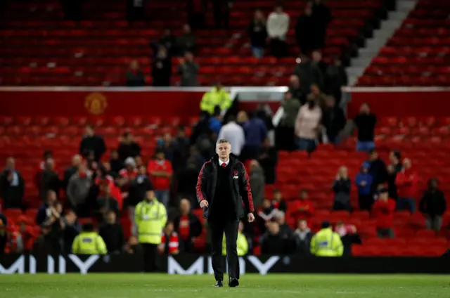 Ole Gunnar Solskjaer walks on to the pitch at full time, with empty seats in the background