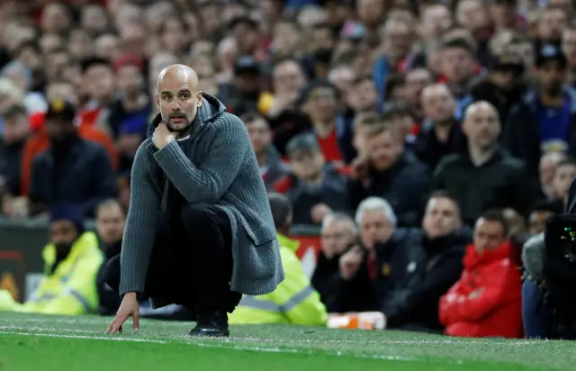 Pep Guardiola kneels down in his technical area