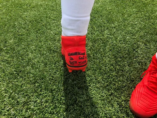 FC United of Manchester white player's boot with 'FA People's Cup' champions written on back.