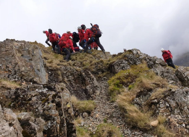 MR team carrying casulaty over rocks