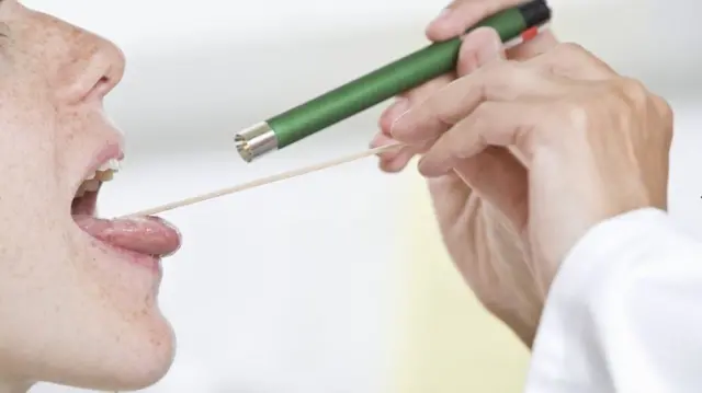 A woman having her throat checked (generic image)