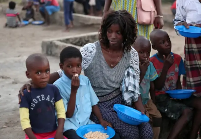 Virginia Samuel sits with two of her four children at a camp for people displaced in the aftermath of Cyclone Idai in Beira, Mozambique, March 26, 2019. Picture taken March 26, 2019