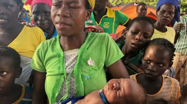 Amélia cradles her daughter Sara at an accommodation centre in Dombe