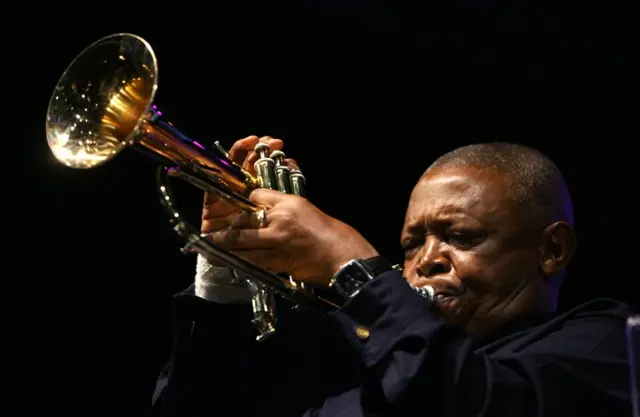 Hugh Masekela playing a trumpet