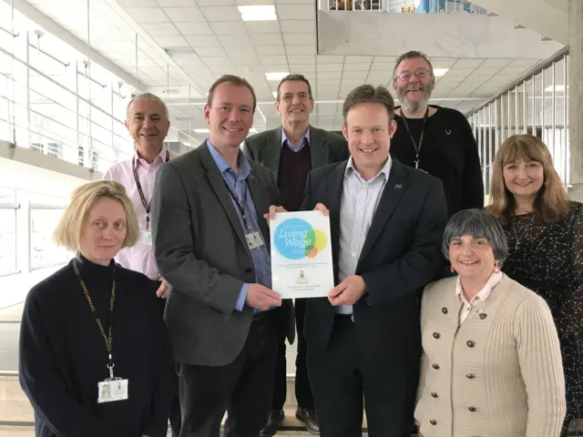 group of people holding a certificate