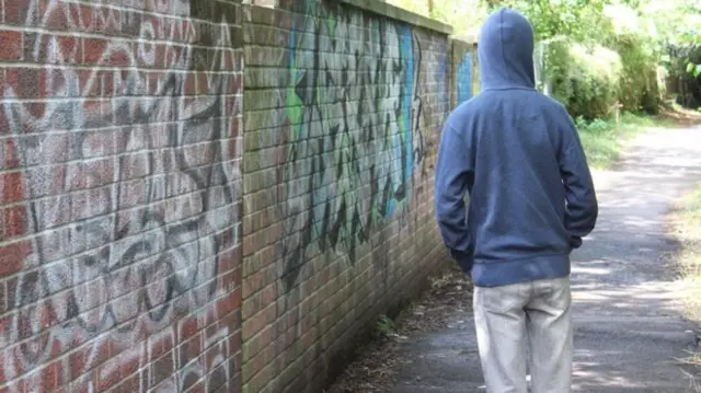 Hooded man in an alleyway