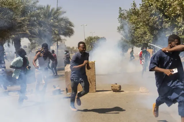 Demonstrators run from tear gas as they take part in a protest demanding the departure of Sudanese President Omar al-Bashir, in Khartoum, Sudan, 07 April 2019.