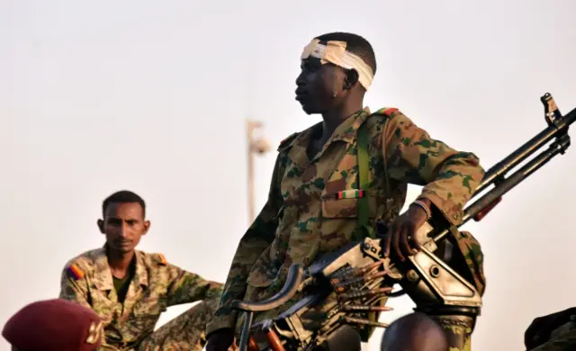 Sudanese military soldiers look on as demonstrators attend a protest demanding Sudanese President Omar al-Bashir to step down outside the defence ministry in Khartoum, Sudan on April 8, 2019