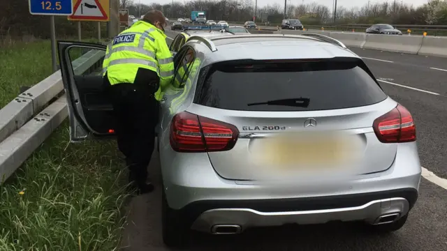 A silver car on the M621