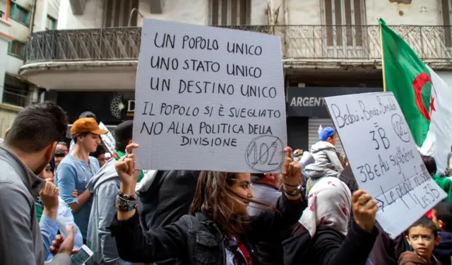 Algerians march with signs bearing political slogans during an anti-government demonstration in the northern coastal city of Oran on April 5, 2019.