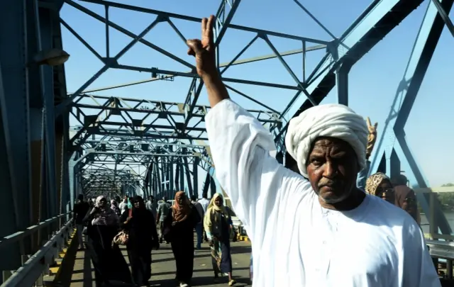 A Sudanese demonstrator gestures during a protest demanding Sudanese President Omar Al-Bashir to step down along a bridge in Khartoum, Sudan on April 8, 2019