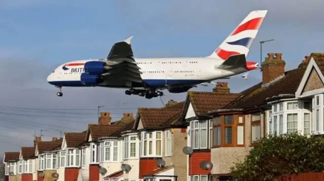 plane above rooftops