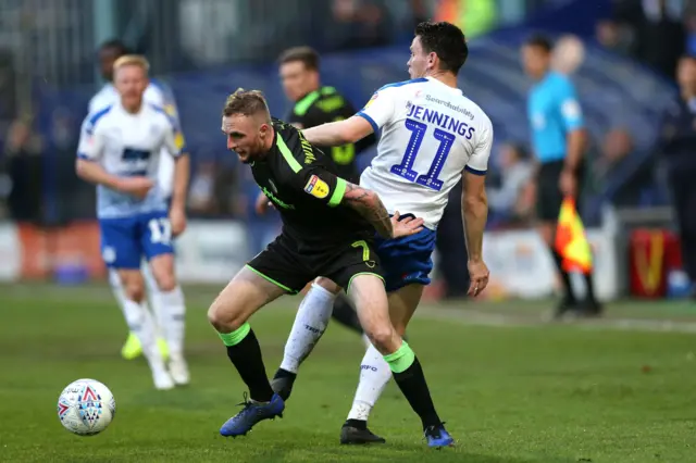 Carl Winchester of Forest Green beats a challenge from Connor Jennings