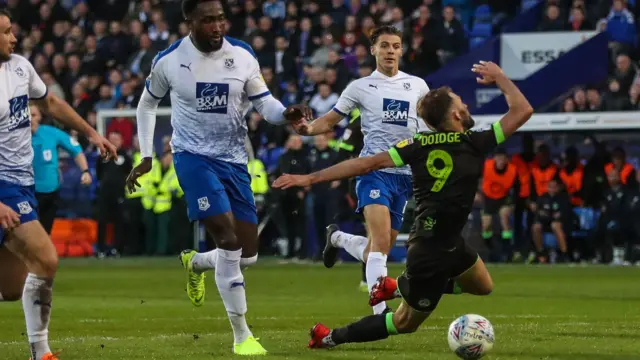 Forest Green Rovers Christian Doidge is brought down by Tranmere Rovers Emmanuel Monthe, but no penalty is given