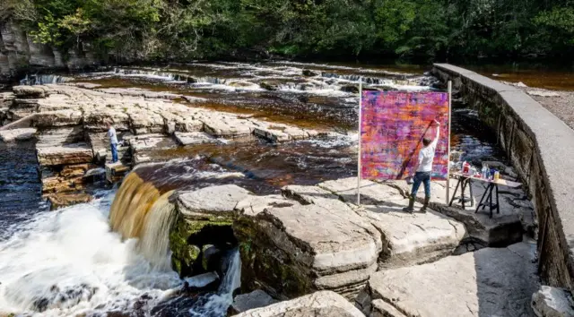 ARTIST PAINTING BY RIVER