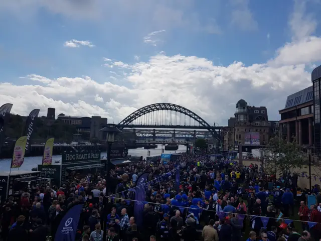 A large crowd of fans Fans stood in front of the Tyne Bridge