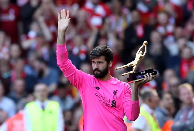 Alisson with the Premier League's golden gloves statue after keeping the most clean sheets over the season