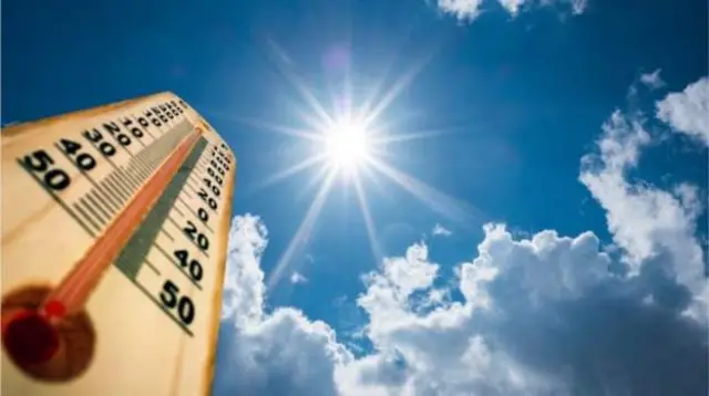 Thermometer against sunny sky