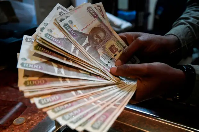 A currency dealer counts Kenyan shillings at a money exchange bureau on September 19, 2018 in the Kenyan capital Nairobi.