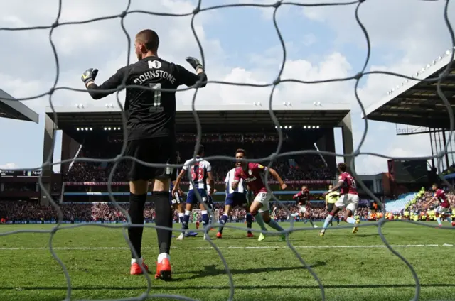 am Johnstone of West Bromwich Albion reacts as Andre Green of Aston Villa celebrates his team"s first goal during the Sky Bet Championship Play-off semi final