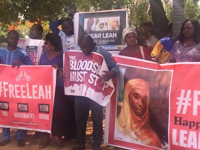 Crowds holding banners saying "Bloodshed must stop" and #freeleah.