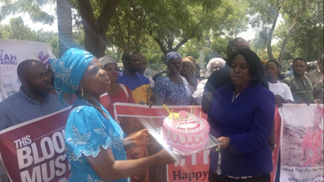 Women holding a cake to celebrate Leah's birthday