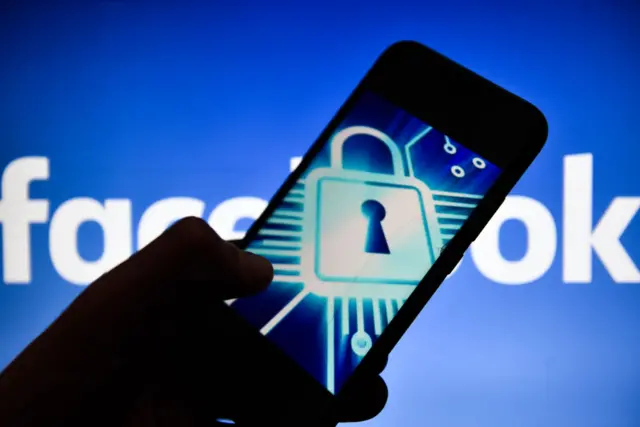 In this photo illustration, the Cyber lock symbol is seen displayed on an Android mobile phone with Facebook logo in the background.