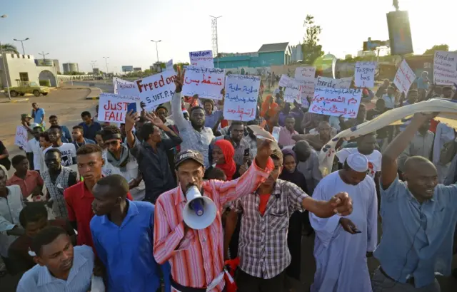 Protesters holding placards and chanting