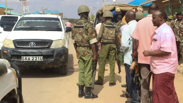 Soldiers standing next to a car