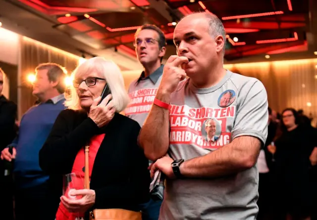 Labor supporters talk on the phone and look nervous at the Labor Party function in Melbourne