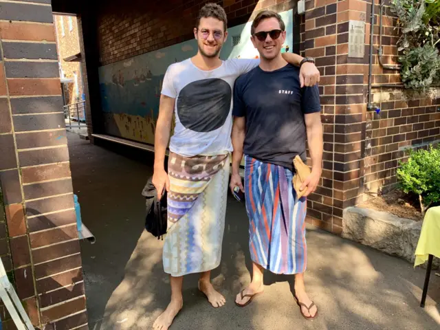 Men voting in sandals and beach towels