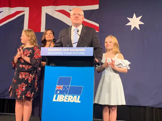 Scott Morrison stands with his family on stage in Sydney