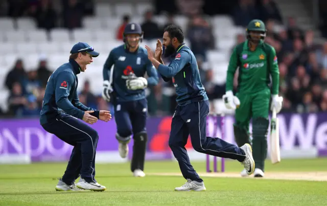 Adil Rashid of England celebrates with captain Eoin Morgan after dismissing Shoaib Malik