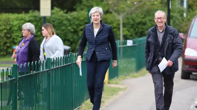 Theresa May and her husband Philip on their way to a polling station