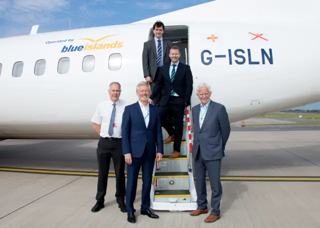 Blue islands executives stand next to an aeroplane