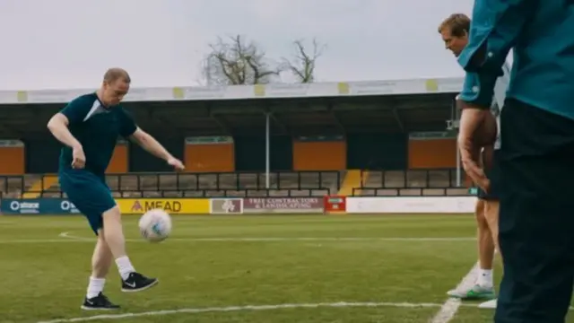 Mark kicking a ball